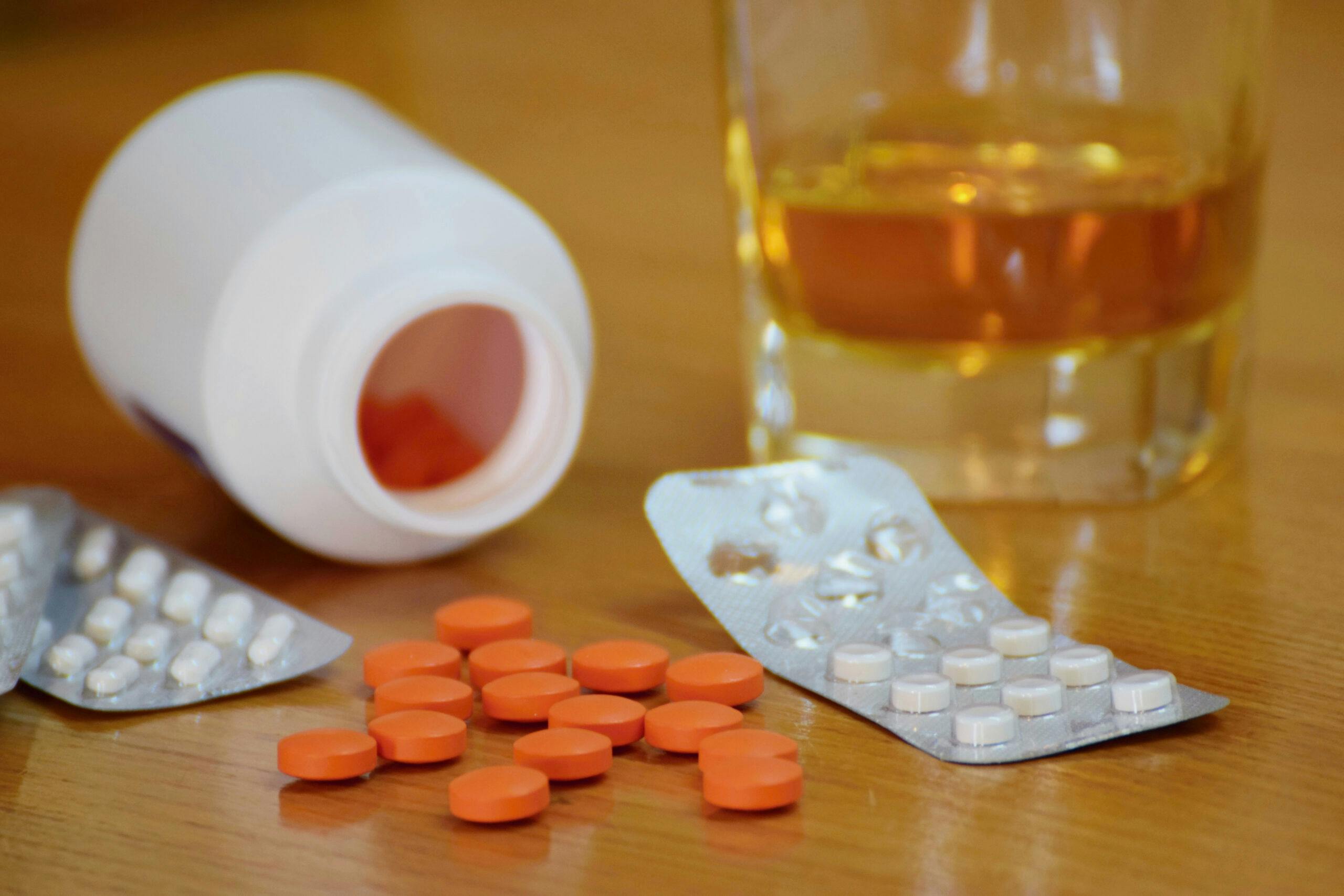 liquor in glass with orange and white pills