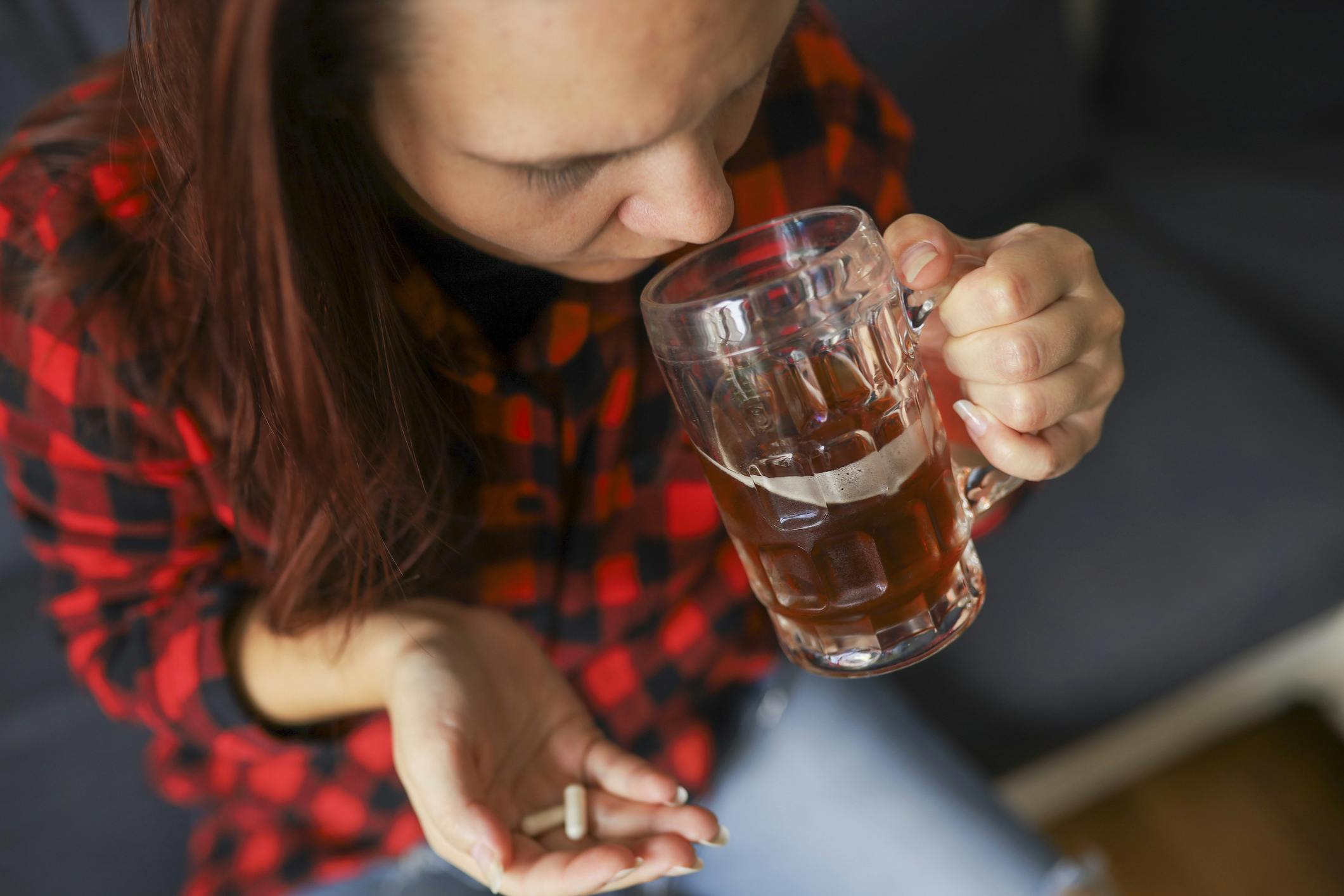 young woman drinking beer and taking concerta pill