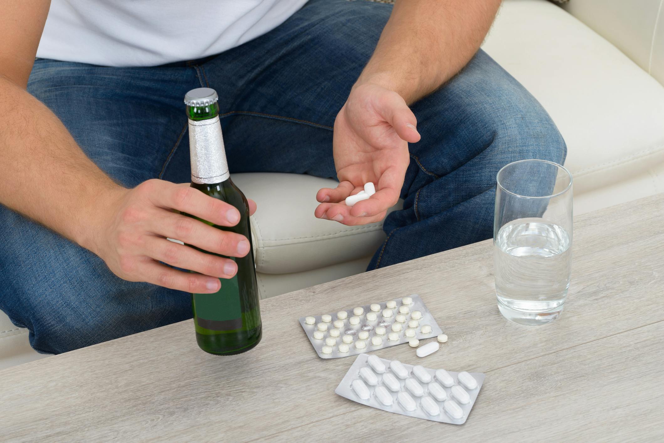 man with beer bottle and white pills clonidine