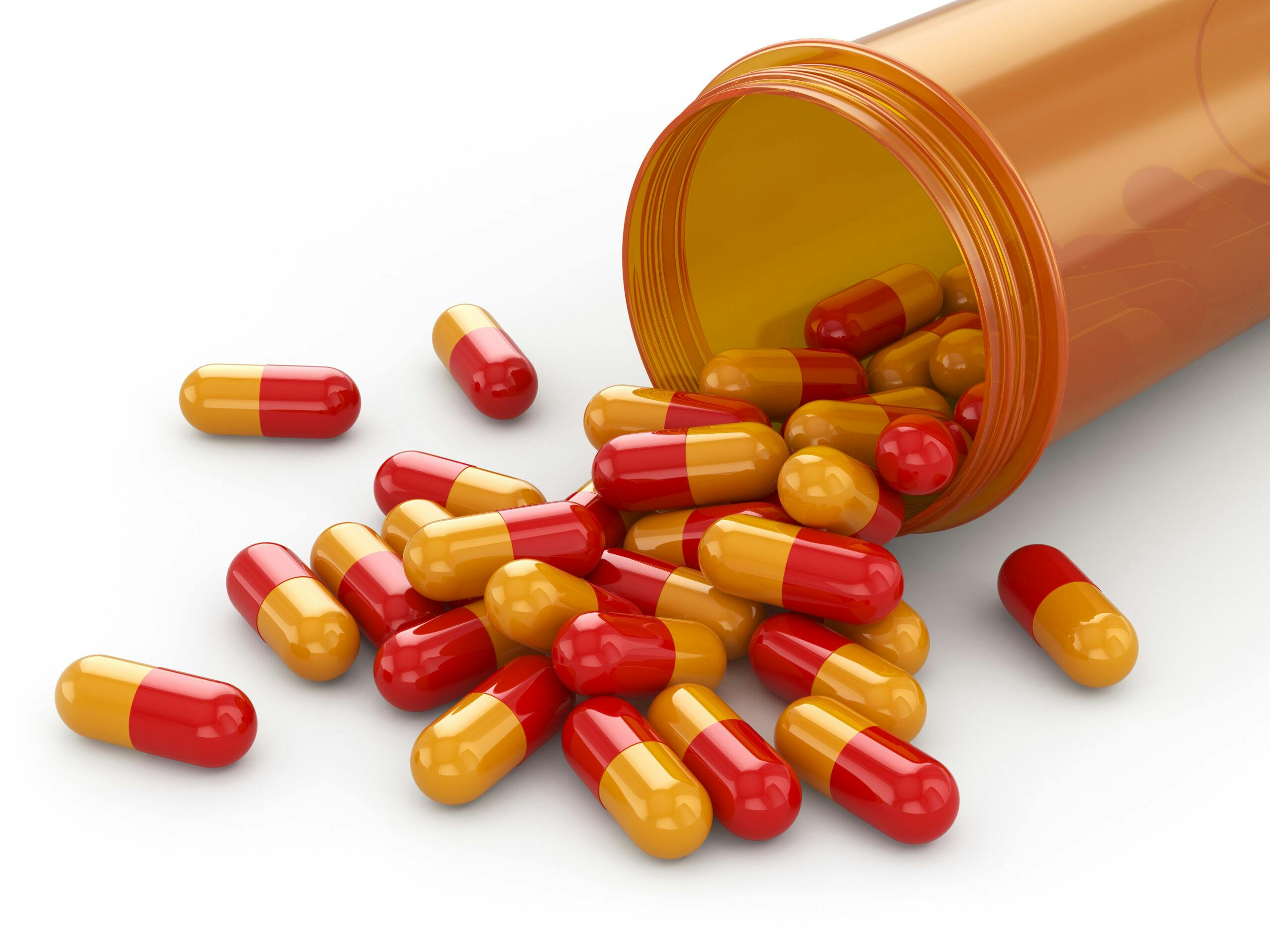 orange red capsules pills dexedrine spilling from rx bottle
