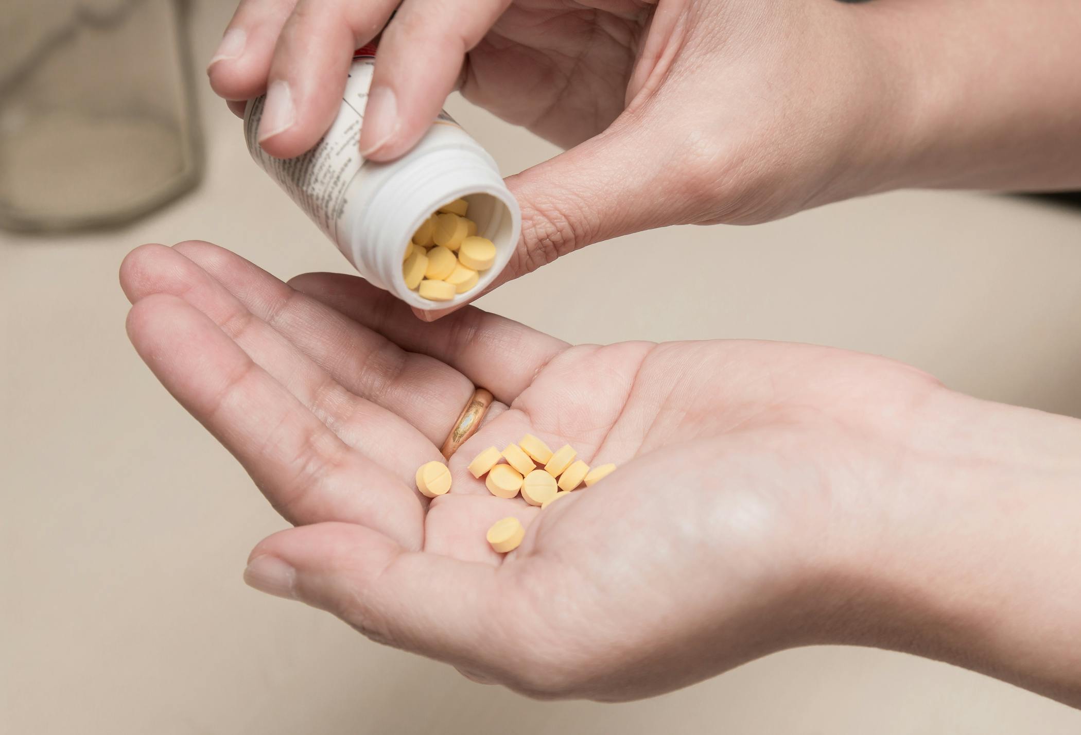 woman holding medicine bottle with yellow diazepam pills