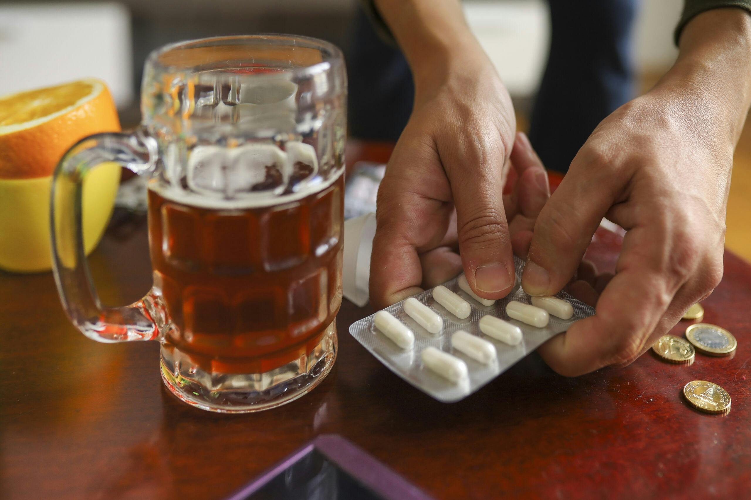 glass of beer man hands white pills