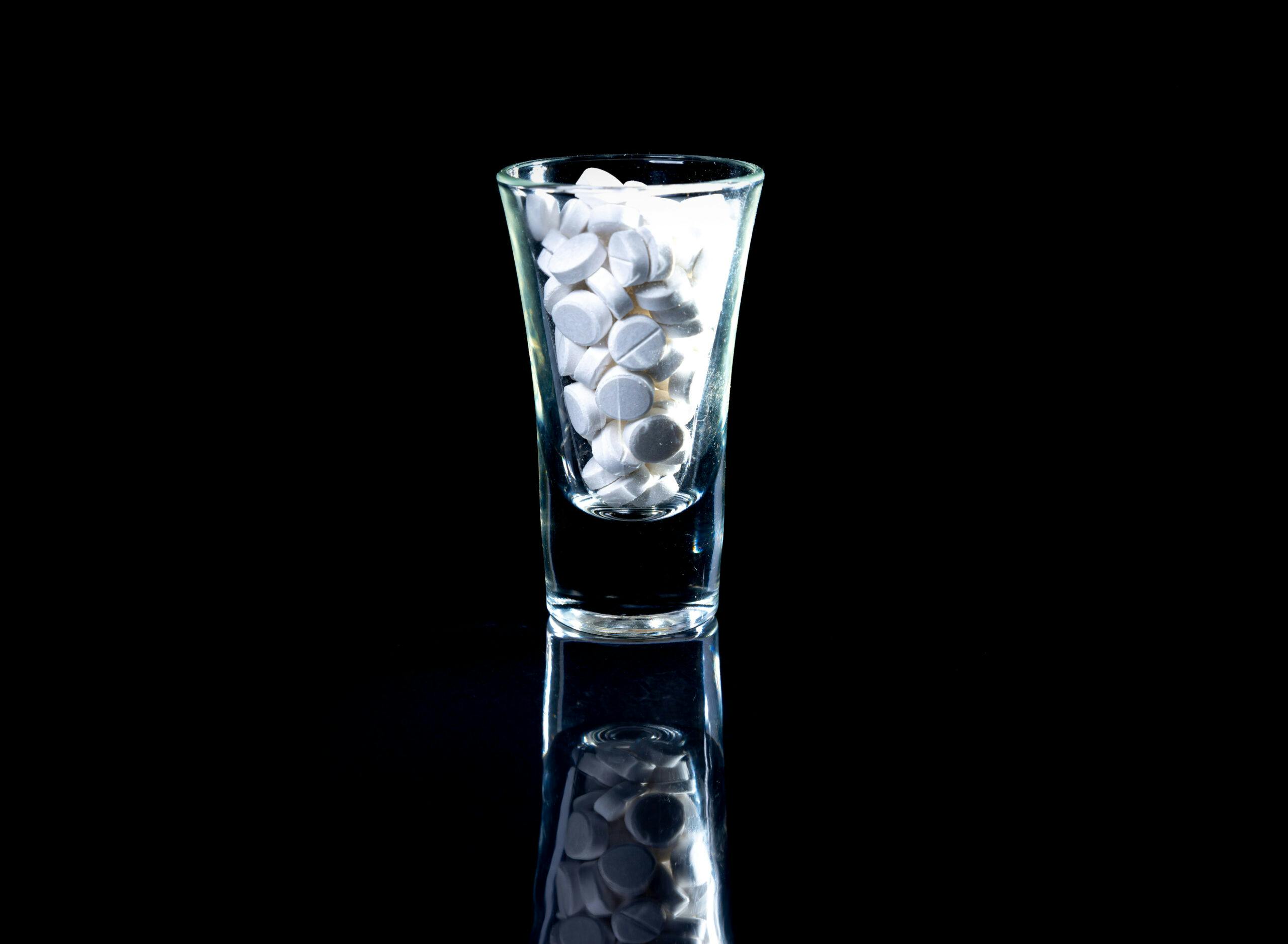 white pills in shot glass