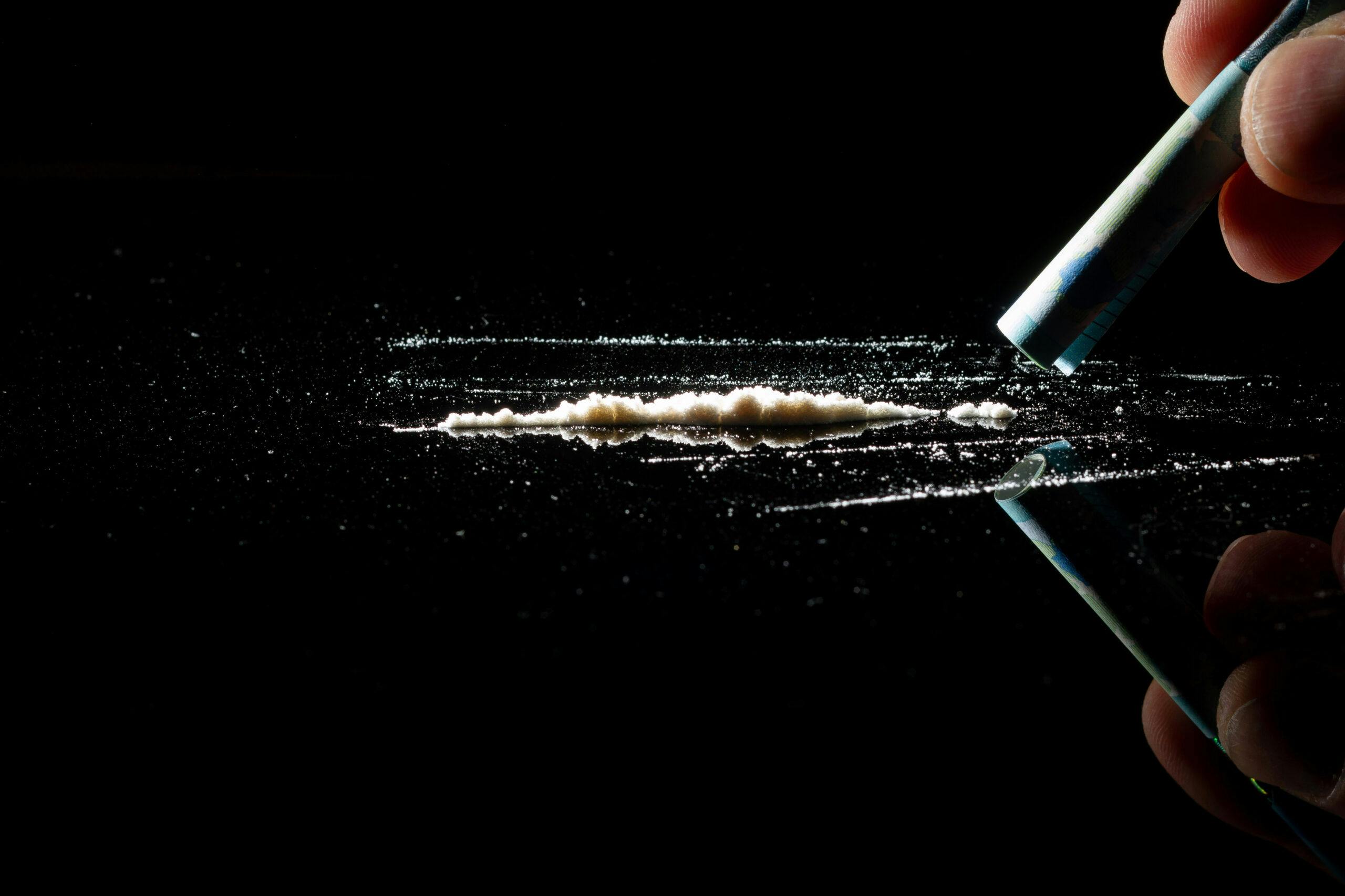 line of cocaine with rolled dollar bill to snort