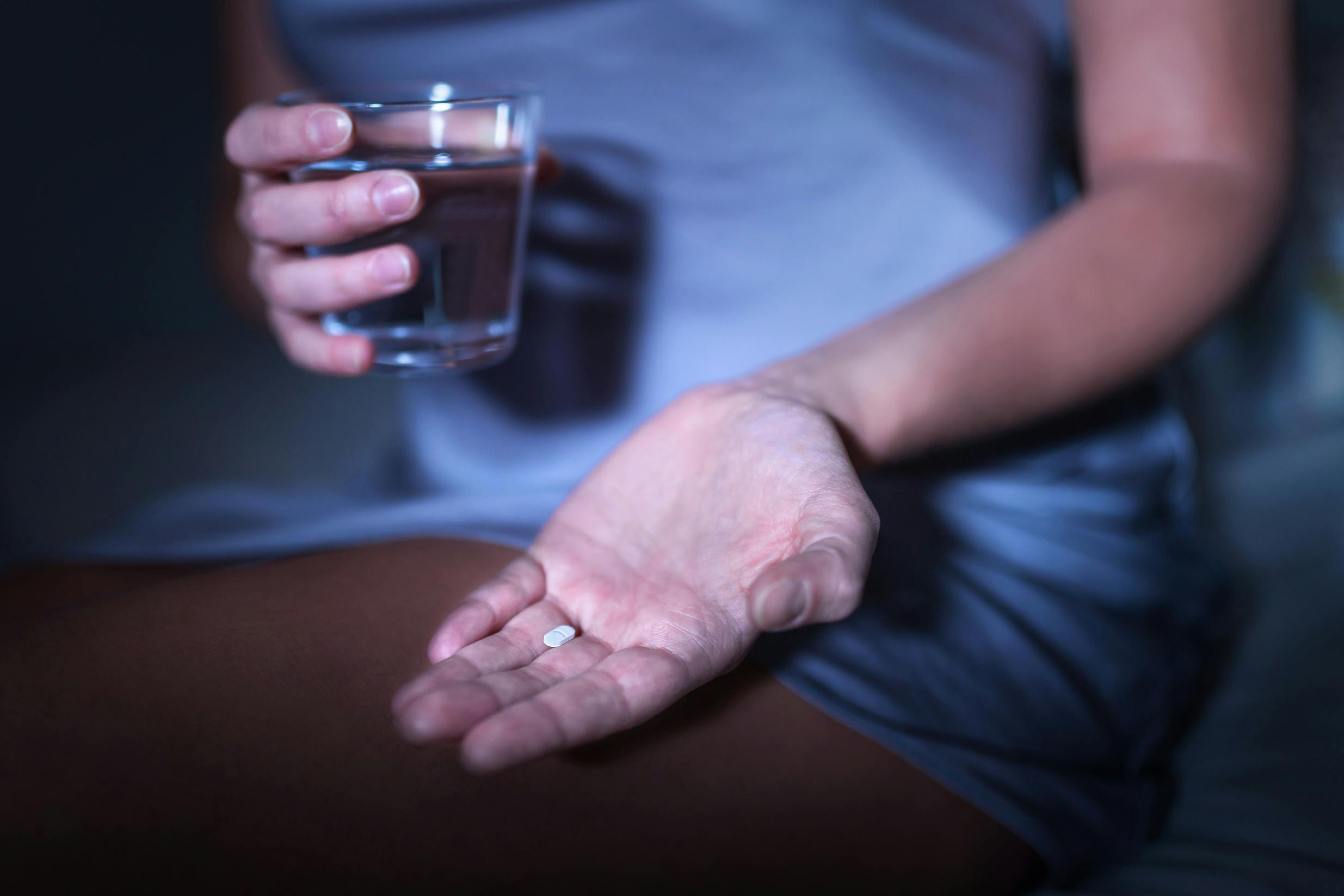woman holding pill and water sleep