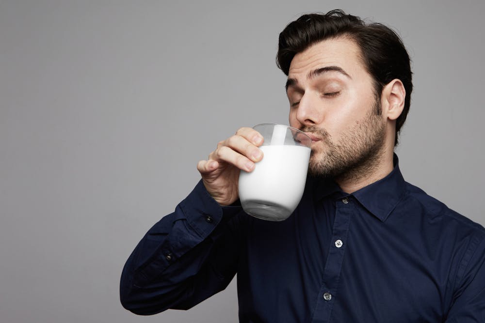 young man drinking glass of milk