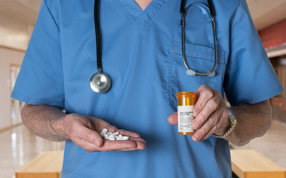 doctor holding oxycodone pills