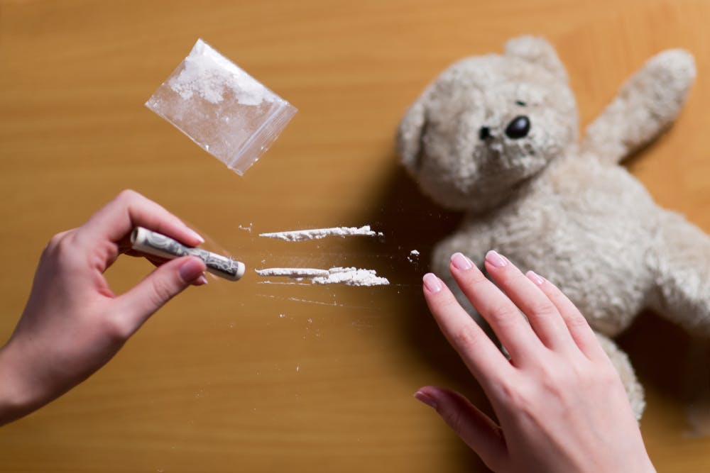 woman snorting lines of cocaine with teddy bear
