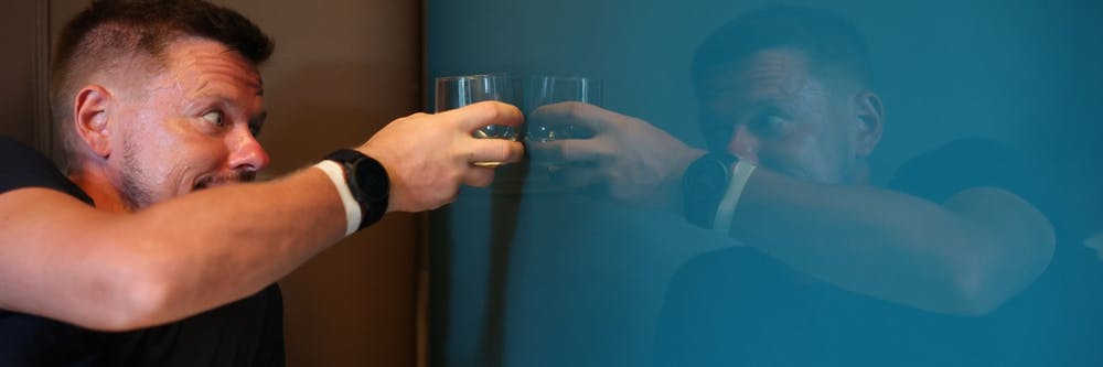 man drinking whiskey with himself in mirror