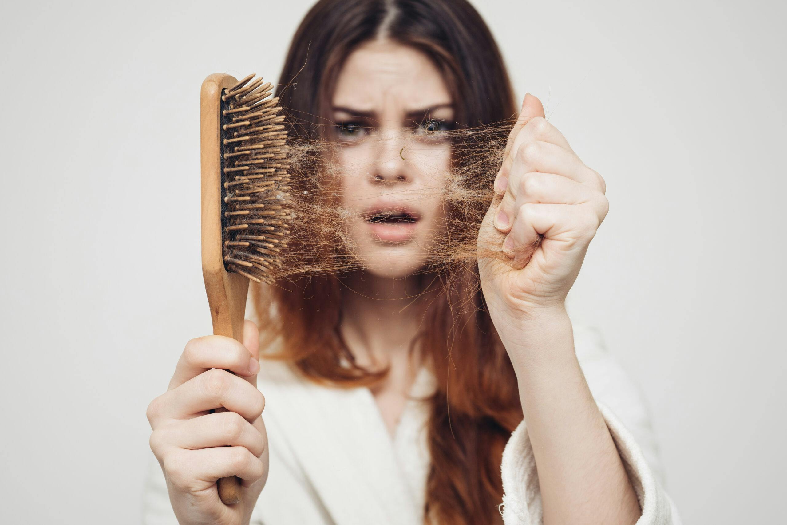 woman with hair comb hair loss