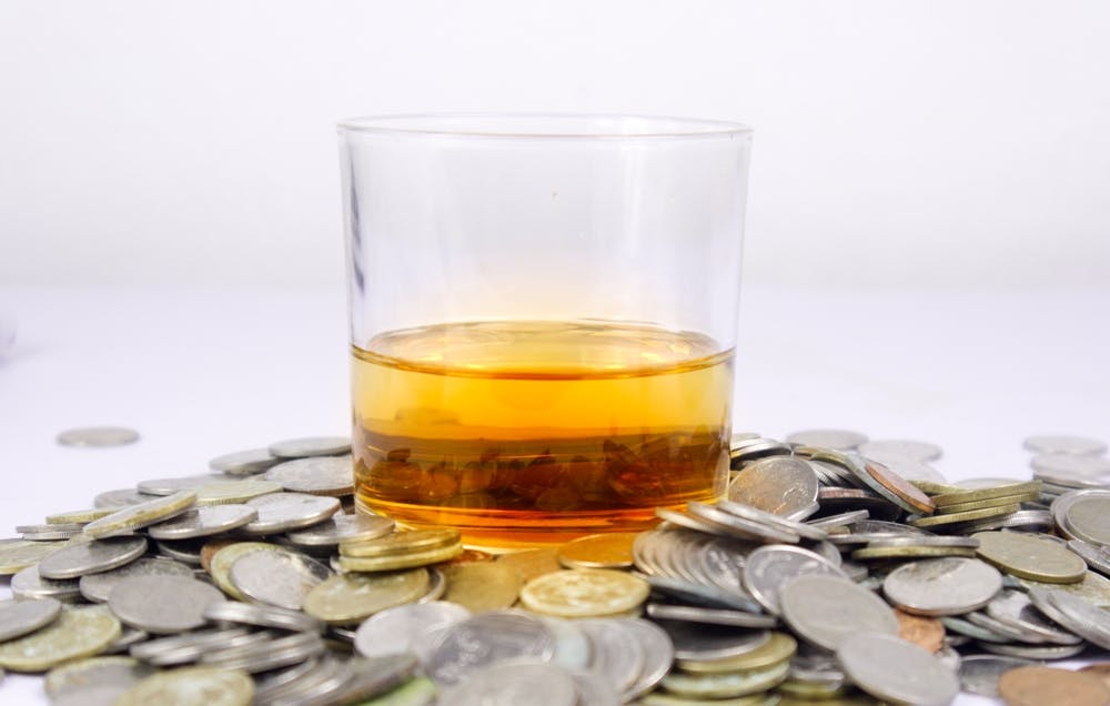 cost alcohol rehab treatment liquor glass on coins