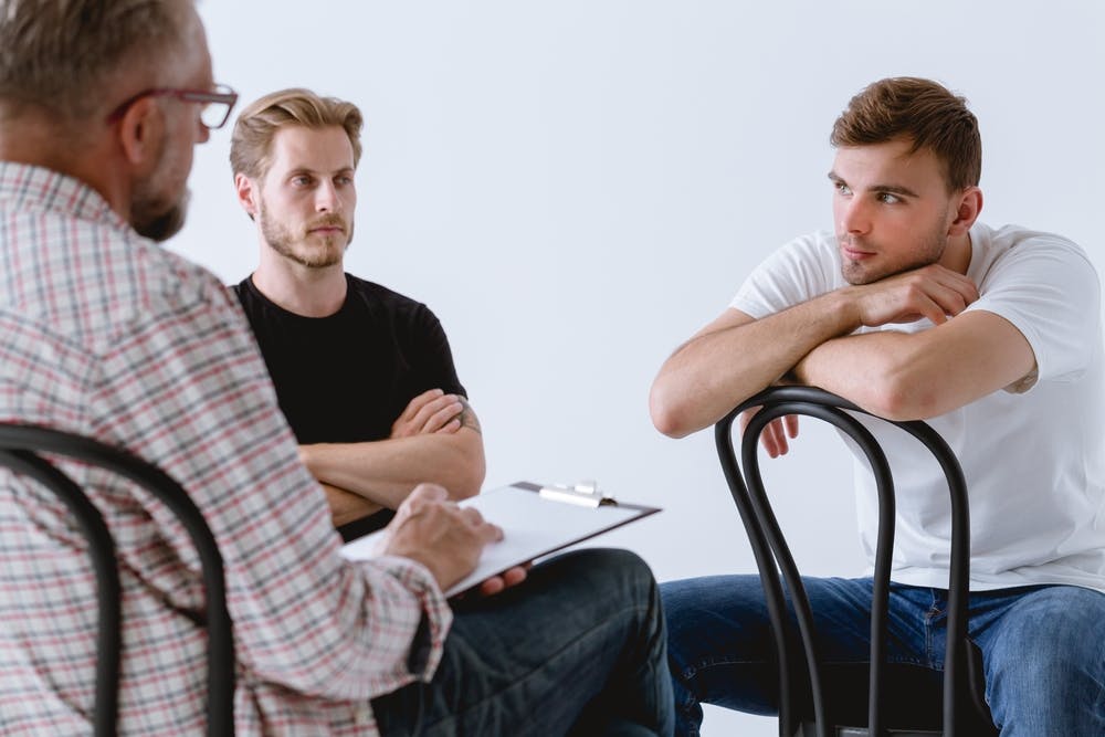 two men in therapy with therapist