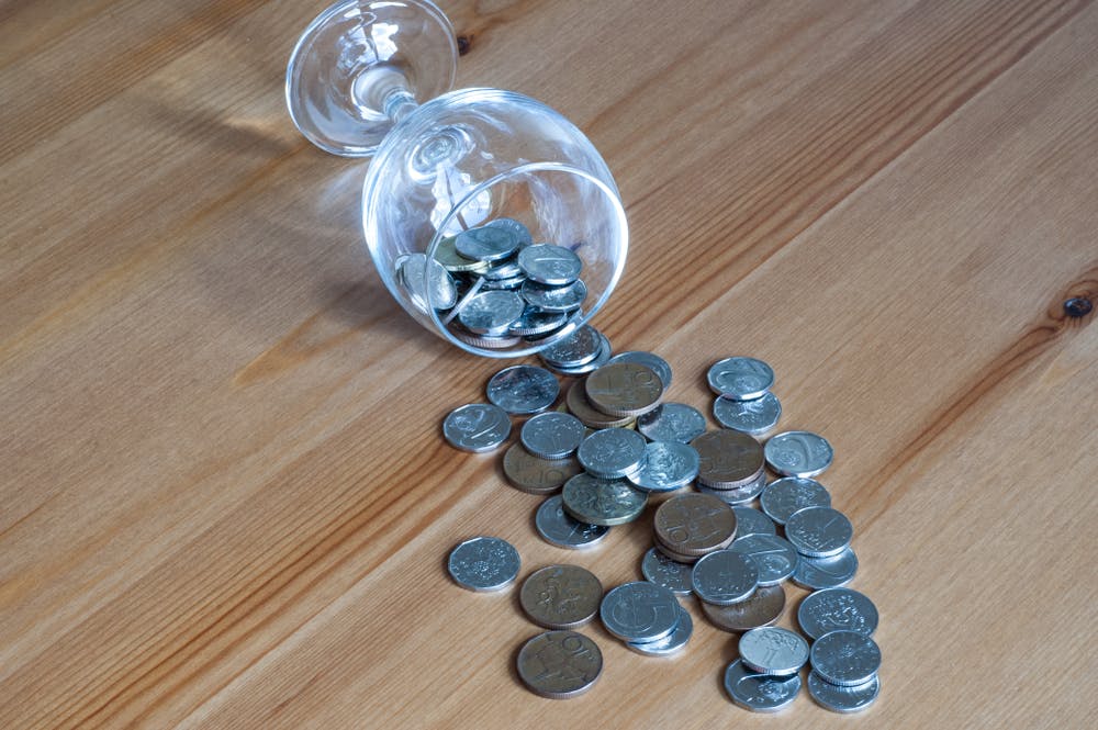 wine glass with coins spilling out