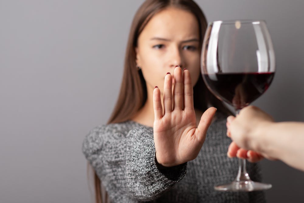 woman refusing a glass of wine