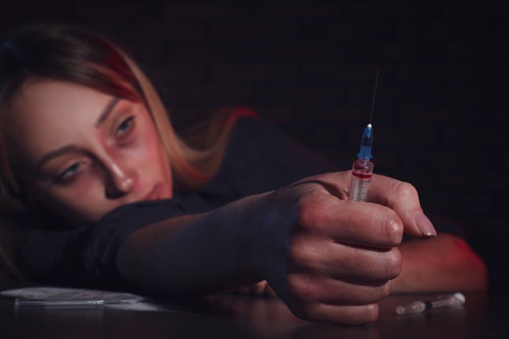 woman meth addict with syringe and tired eyes