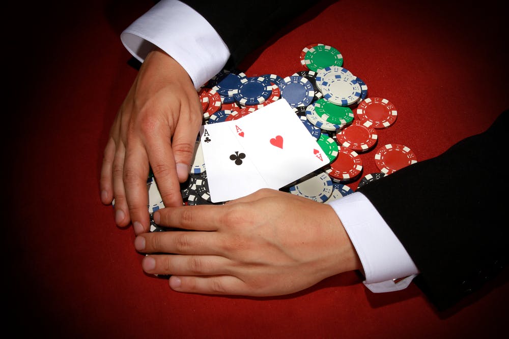 hands reaching for poker chips and cards gambling