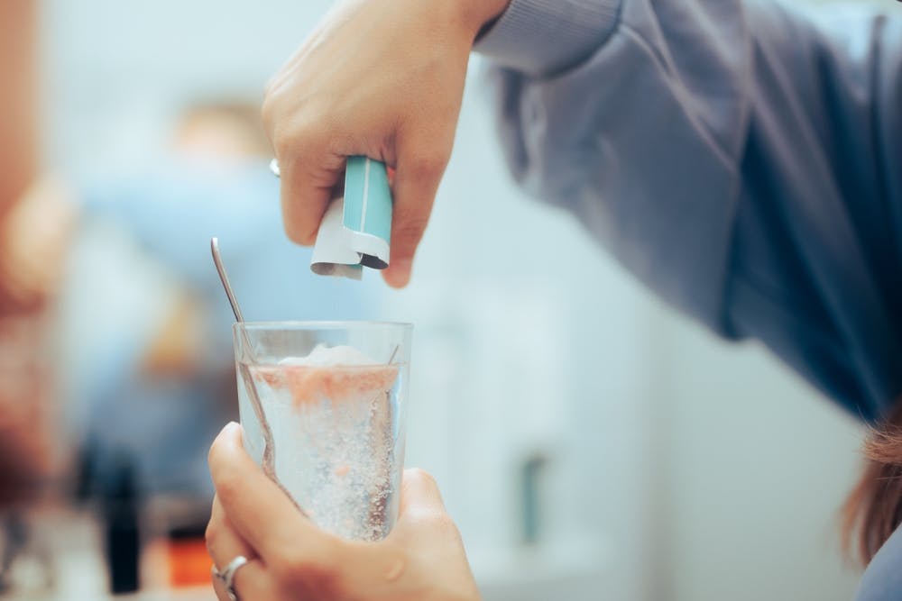 woman pouring drug detox mix into glass
