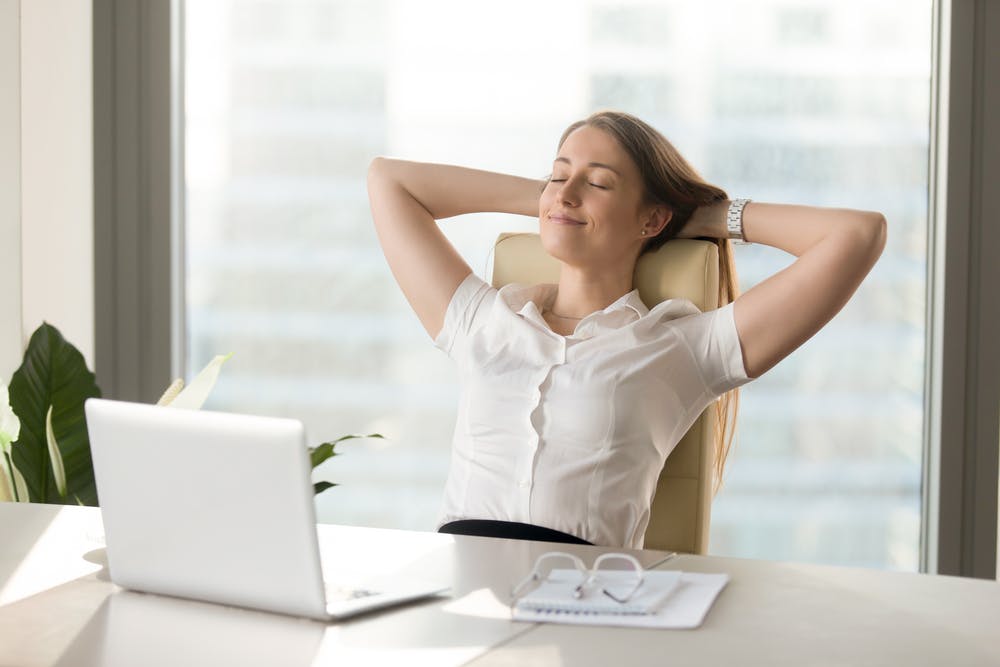 Calm smiling businesswoman relaxing at comfortable office chair hands behind head