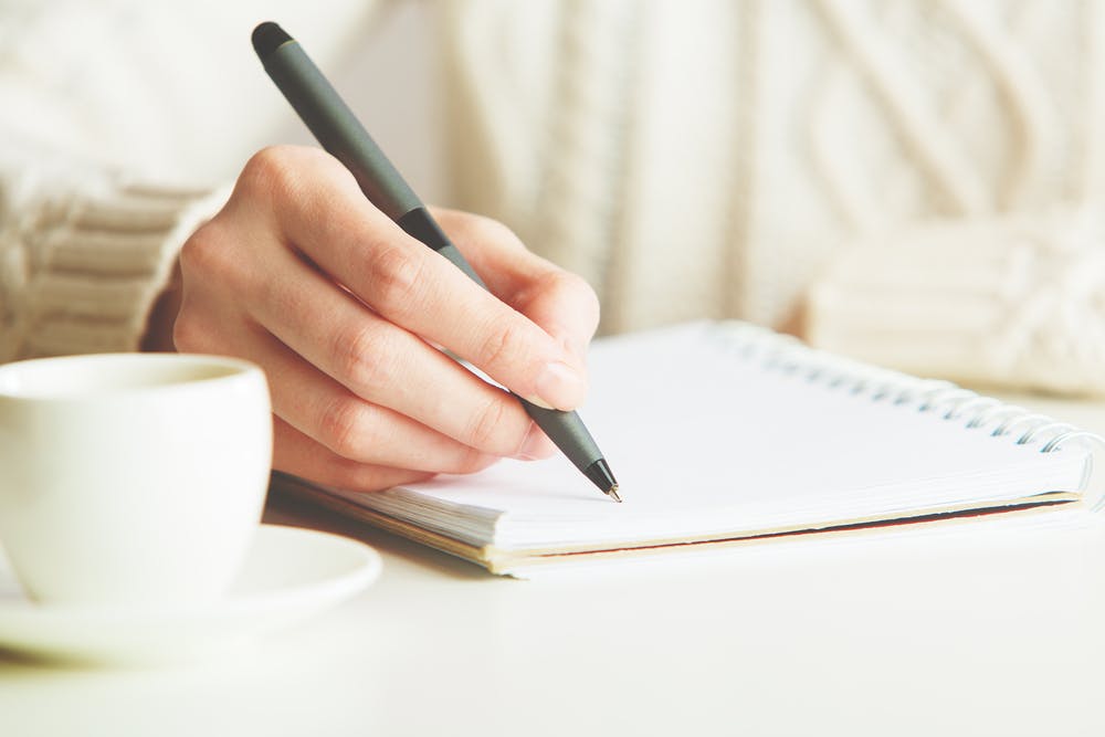 woman writing letter in notebook
