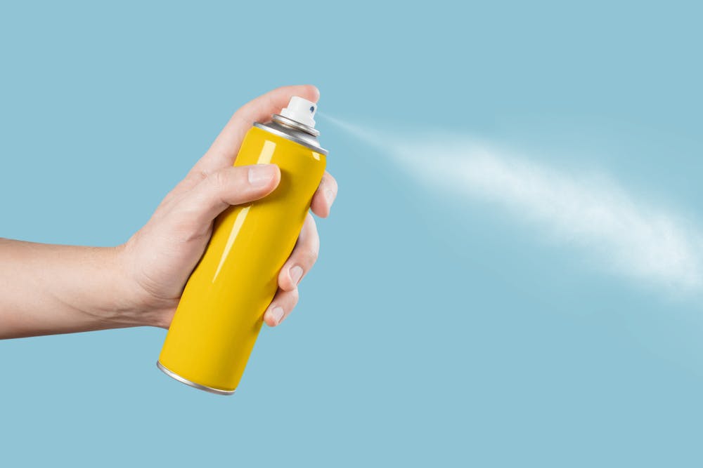 hand spraying aerosol can